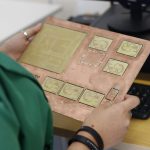 Técnico examina uma placa de circuito impresso em um laboratório de eletrônica.