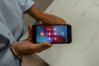 Pessoa segura um smartphone que exibe a tela de chamada recebida.