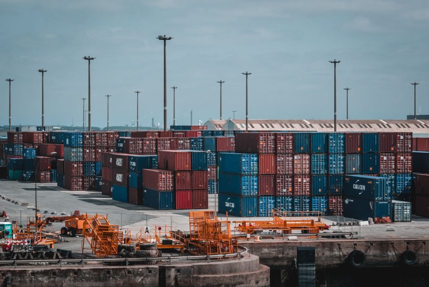 Contêineres coloridos empilhados em uma área portuária industrial.